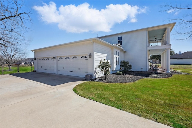 view of side of home featuring a lawn, a balcony, concrete driveway, and an attached garage