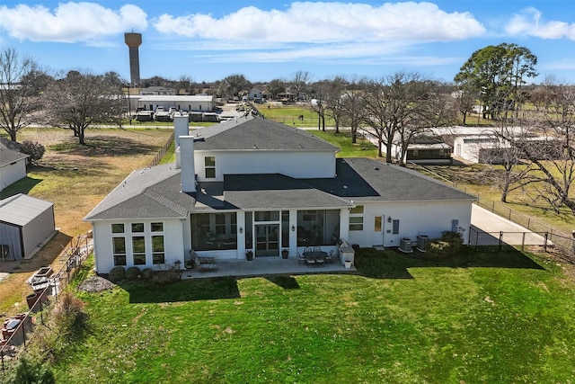 back of house featuring a yard, a fenced backyard, a sunroom, a shingled roof, and a patio area