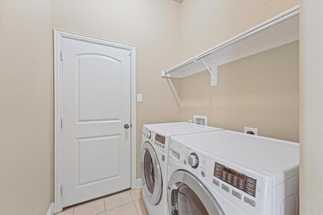 washroom with washer and dryer, laundry area, and light tile patterned floors