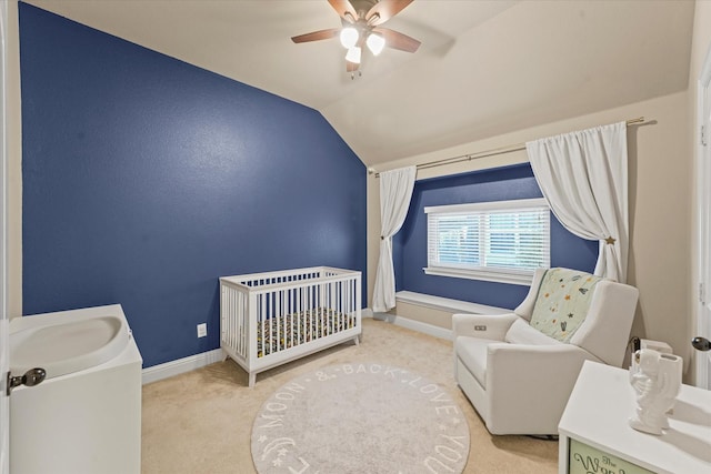 bedroom with a crib, baseboards, ceiling fan, lofted ceiling, and carpet floors