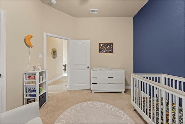 carpeted bedroom with visible vents, a crib, and baseboards