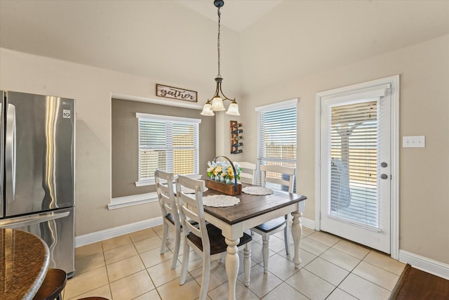 dining room with baseboards, high vaulted ceiling, and light tile patterned flooring