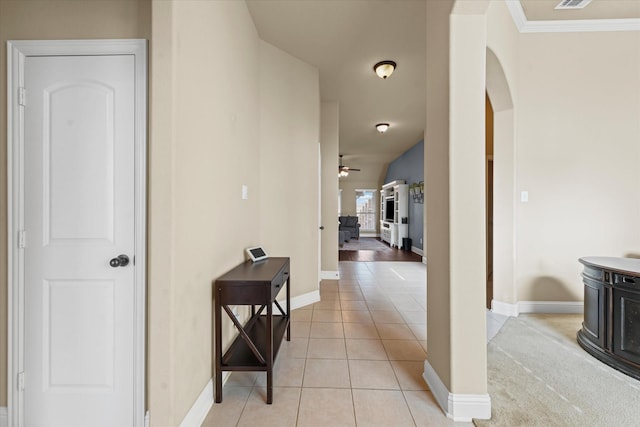 corridor with visible vents, light tile patterned flooring, baseboards, and arched walkways