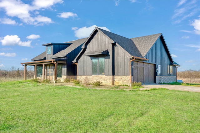 modern inspired farmhouse with driveway, a shingled roof, board and batten siding, a front yard, and an attached garage