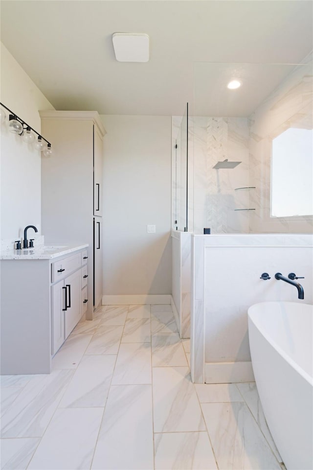 full bathroom with vanity, baseboards, a freestanding tub, a walk in shower, and marble finish floor