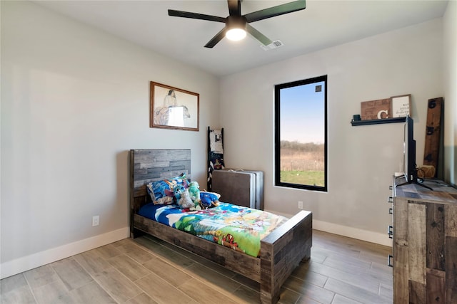 bedroom featuring wood finished floors, baseboards, visible vents, and ceiling fan