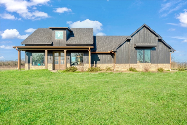 view of front of home featuring french doors, a shingled roof, and a front yard