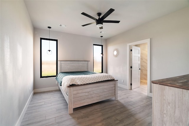 bedroom featuring baseboards, visible vents, and wood finish floors