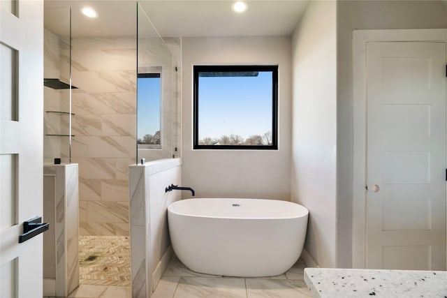 full bathroom with a freestanding tub, recessed lighting, a walk in shower, and marble finish floor