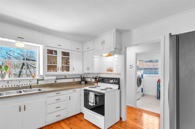 kitchen with plenty of natural light, freestanding refrigerator, a sink, under cabinet range hood, and white electric range