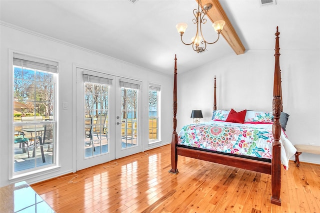 bedroom featuring a chandelier, multiple windows, hardwood / wood-style floors, and access to outside