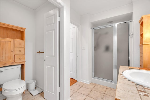 full bath featuring baseboards, a stall shower, a sink, tile patterned floors, and toilet