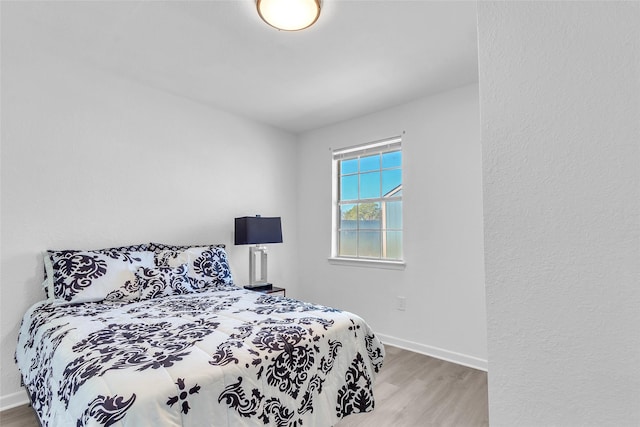 bedroom featuring baseboards and wood finished floors