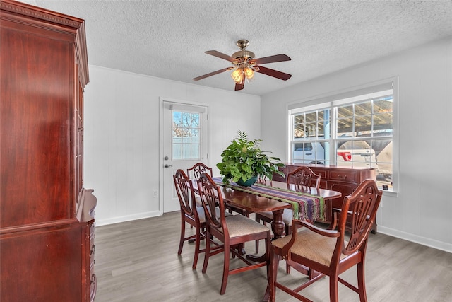 dining space featuring a textured ceiling, wood finished floors, and ceiling fan