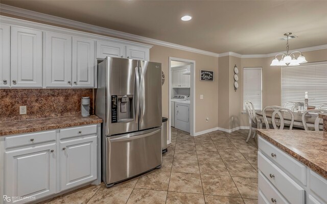 kitchen featuring crown molding, stainless steel fridge with ice dispenser, washer and clothes dryer, an inviting chandelier, and white cabinetry