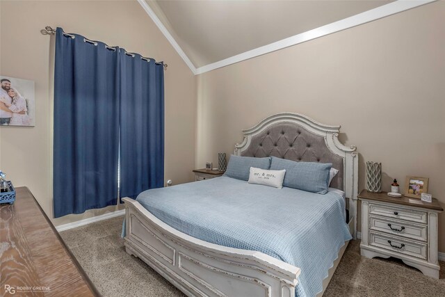 carpeted bedroom with crown molding and lofted ceiling