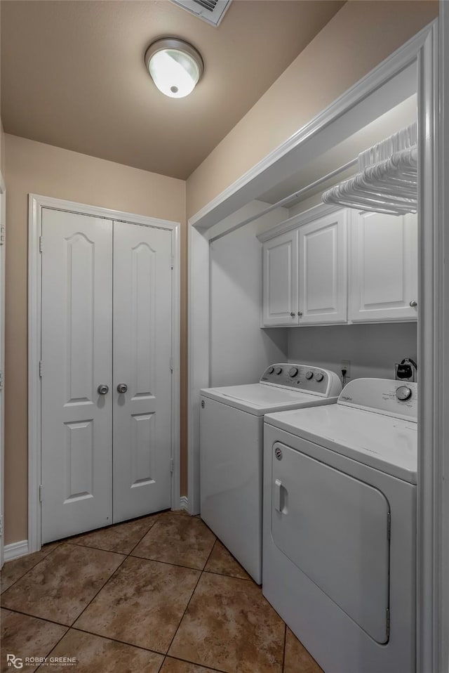 laundry room featuring tile patterned floors, cabinet space, and separate washer and dryer