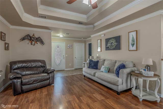 living area featuring visible vents, a raised ceiling, wood finished floors, and a ceiling fan