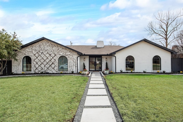 view of front facade featuring brick siding, a front lawn, and a shingled roof