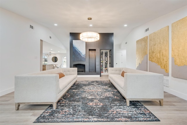 living room with visible vents, recessed lighting, light wood-style floors, baseboards, and vaulted ceiling