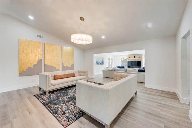 living area with visible vents, light wood-style flooring, recessed lighting, an inviting chandelier, and baseboards