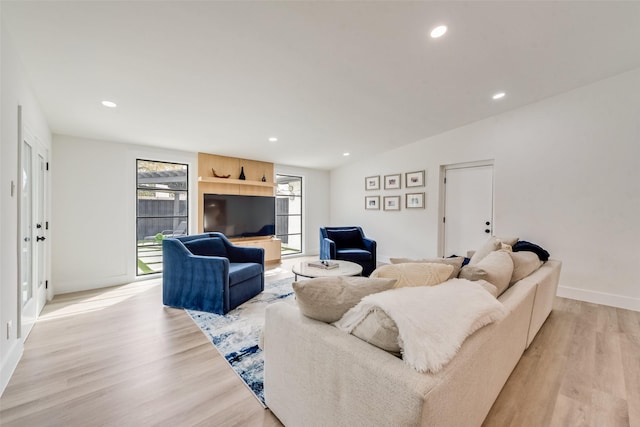 living area featuring recessed lighting, baseboards, vaulted ceiling, and light wood finished floors