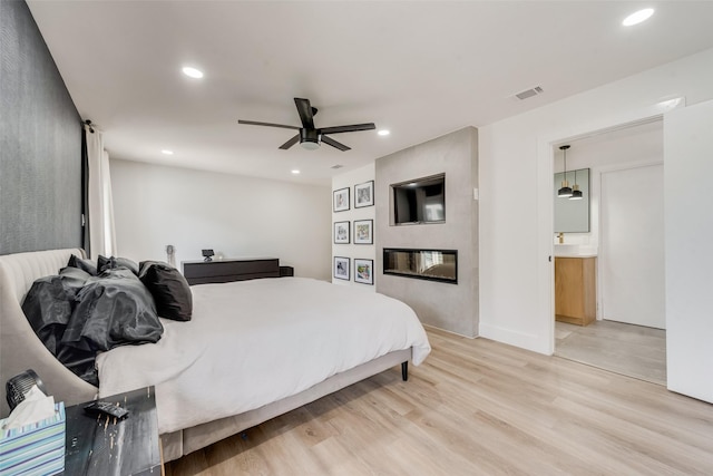 bedroom with visible vents, ceiling fan, light wood-type flooring, recessed lighting, and a fireplace