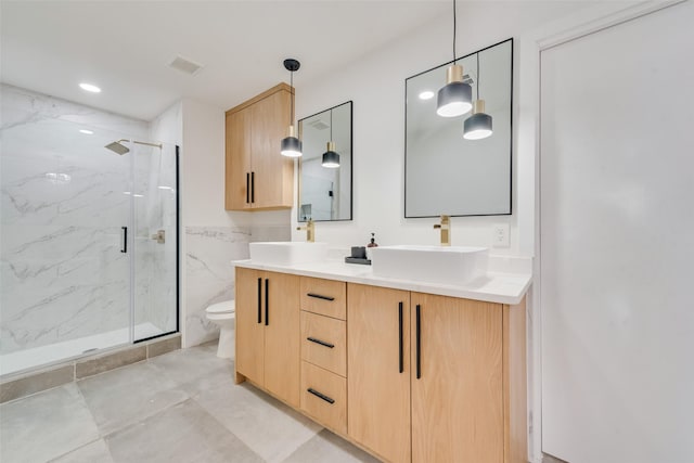 full bath with a marble finish shower, visible vents, toilet, and a sink