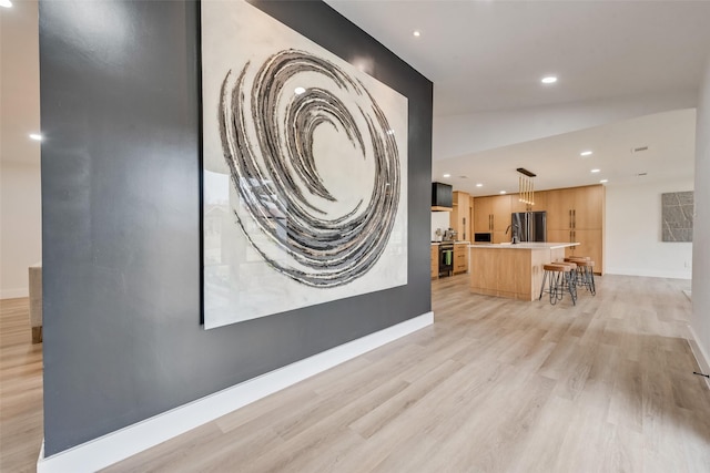 interior space featuring recessed lighting, light wood-style flooring, and baseboards