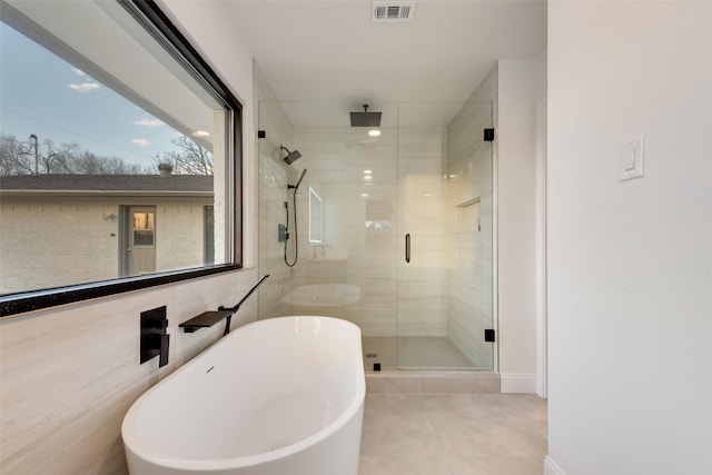 bathroom with tile patterned floors, visible vents, a freestanding bath, and a stall shower