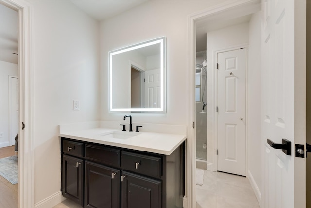 bathroom featuring tile patterned flooring, vanity, and baseboards