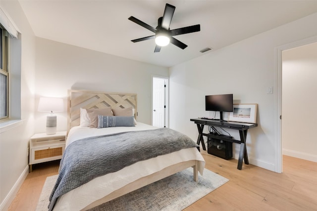 bedroom with a ceiling fan, visible vents, baseboards, and light wood-type flooring