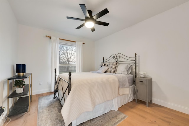 bedroom with light wood-style flooring, baseboards, and ceiling fan