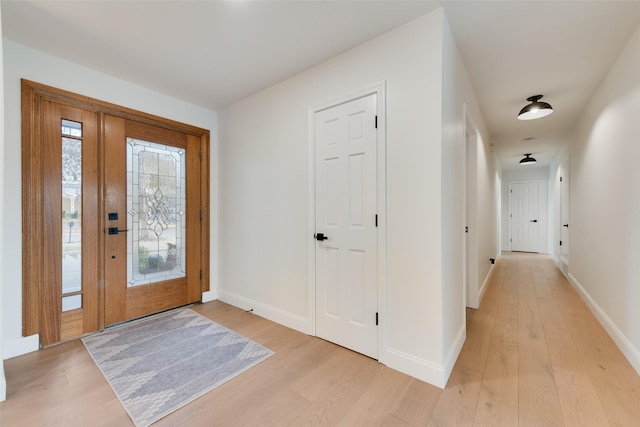 entryway with baseboards and light wood-style floors