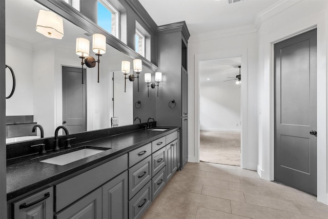 bathroom featuring double vanity, ornamental molding, a ceiling fan, and a sink