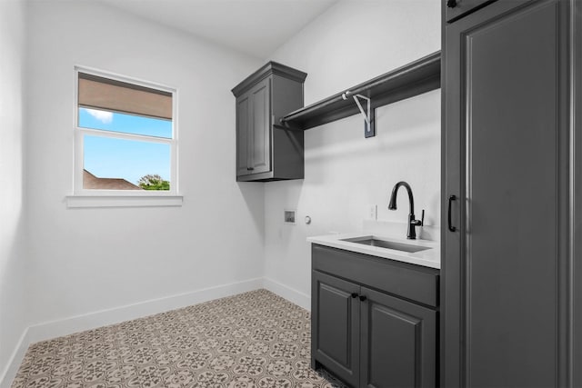 laundry area with a sink, baseboards, cabinet space, and washer hookup