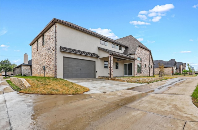 view of front facade with concrete driveway, stone siding, roof with shingles, and stucco siding