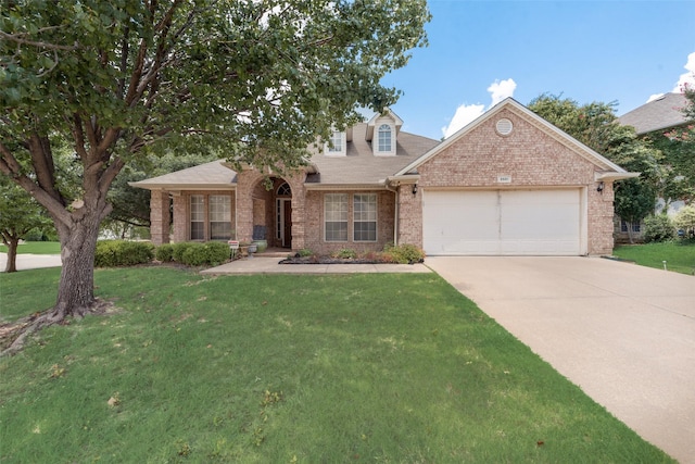 view of front facade with brick siding, driveway, an attached garage, and a front yard