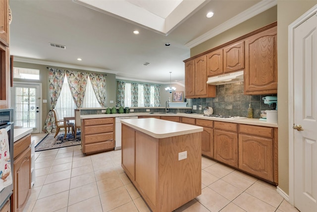 kitchen with white appliances, visible vents, a peninsula, a sink, and under cabinet range hood