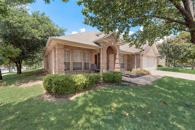 view of front facade with brick siding, driveway, a front yard, and an attached garage