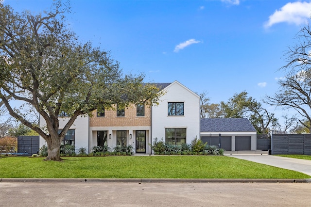 view of front of house with driveway, an attached garage, a front yard, and fence