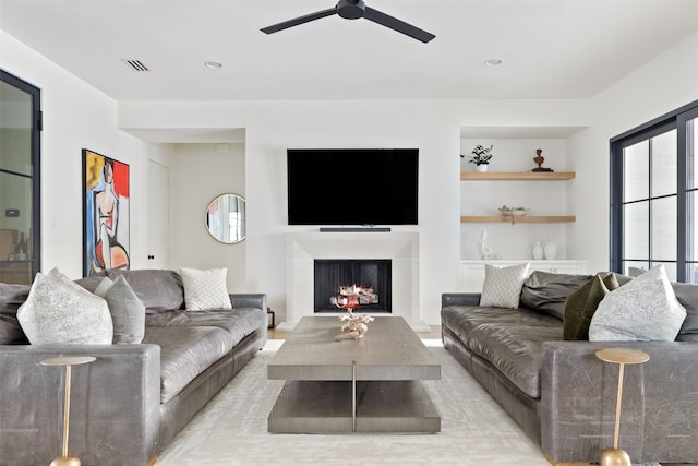 living room with recessed lighting, visible vents, a lit fireplace, and ceiling fan