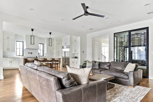 living room with recessed lighting, light wood-style flooring, visible vents, and a ceiling fan