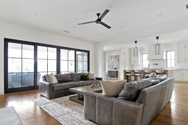 living area with recessed lighting, wood finished floors, visible vents, and ceiling fan