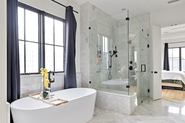 ensuite bathroom featuring a soaking tub, visible vents, a shower stall, and connected bathroom