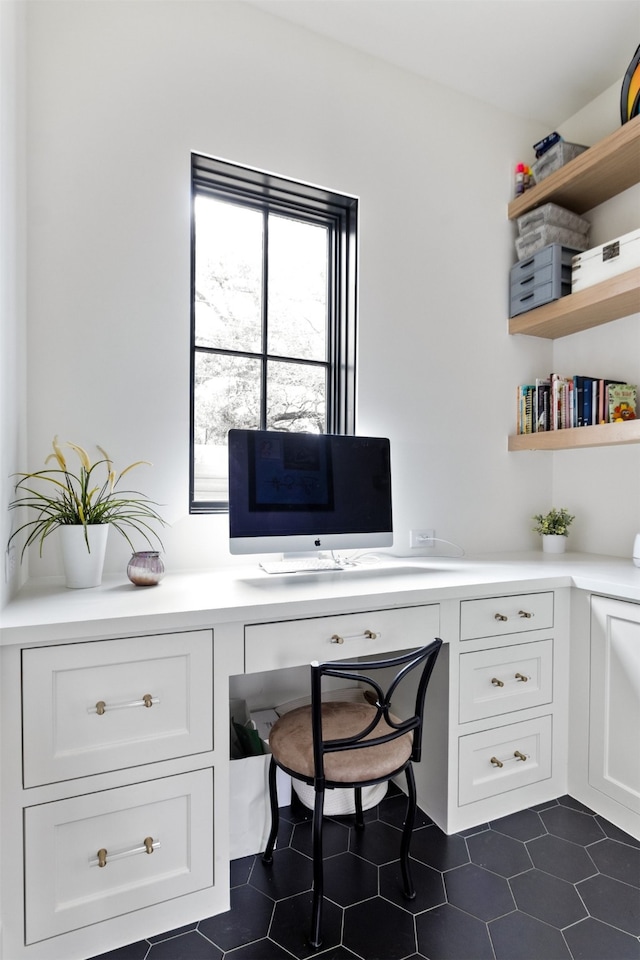 office area featuring dark tile patterned floors and built in study area