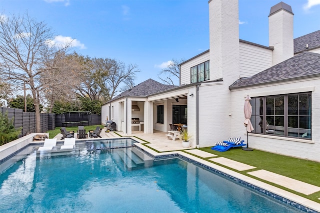 view of pool with a patio area, a pool with connected hot tub, outdoor dry bar, and a fenced backyard