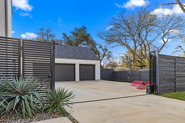 garage featuring fence and driveway