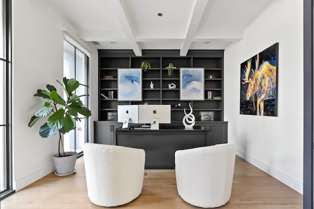 office space with built in shelves, light wood-style floors, baseboards, and coffered ceiling