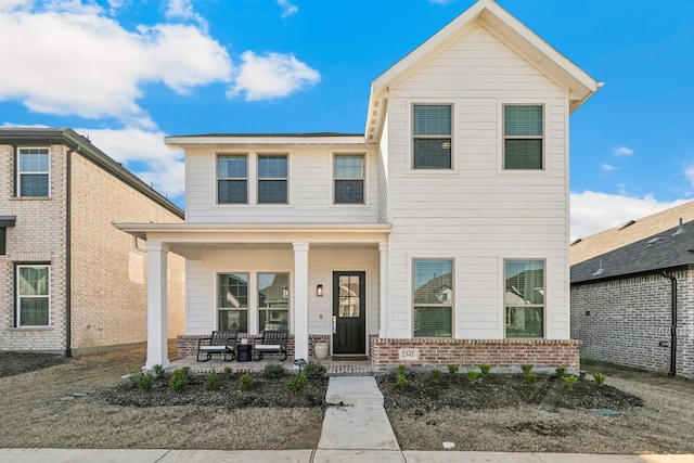 traditional-style home featuring brick siding and a porch